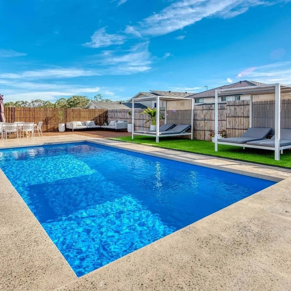 Fibreglass pool with cabanas and sun lounges along one side