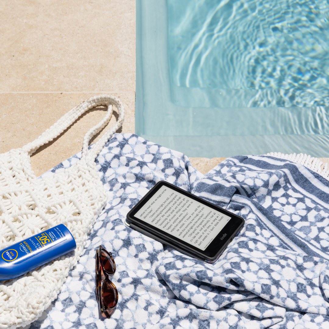 Beach towel, woven bag and sunglasses resting on pool coping